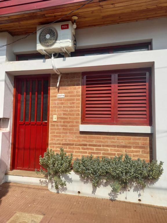 una puerta roja y una ventana en una casa en Monoambiente amplio en Posadas