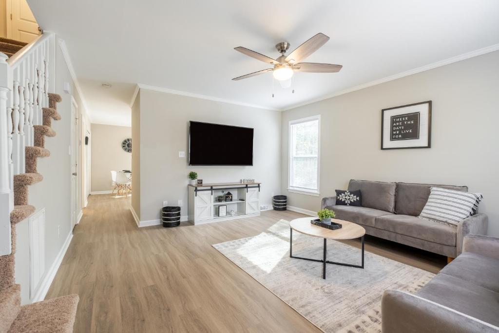 a living room with a couch and a flat screen tv at Modern Stunning SouthPark/Cotswold Home! in Charlotte