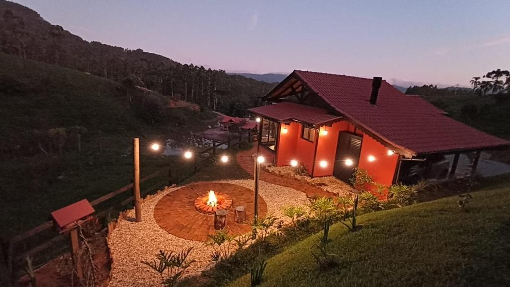 a house with a fire pit in front of it at Refugio Grummel Wald in São Bonifácio