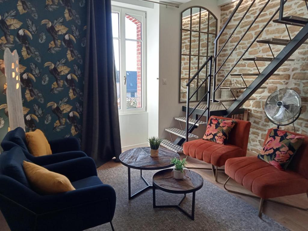 una sala de estar con sofás y mesas y una escalera en tourmaline, en Concarneau