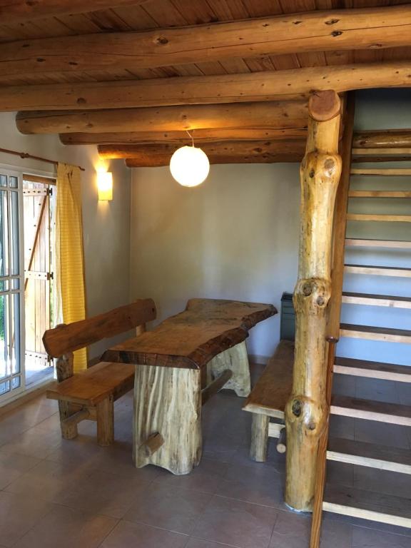 comedor con mesa de madera y bancos en Villa Pehuenia en Villa Pehuenia