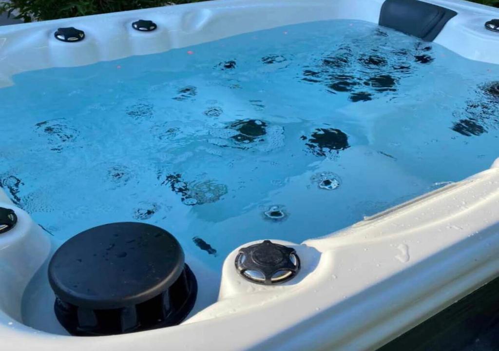 d'une baignoire remplie d'eau bleue avec un objet noir. dans l'établissement Sonnenterrasse mit Whirlpool, à Überlingen