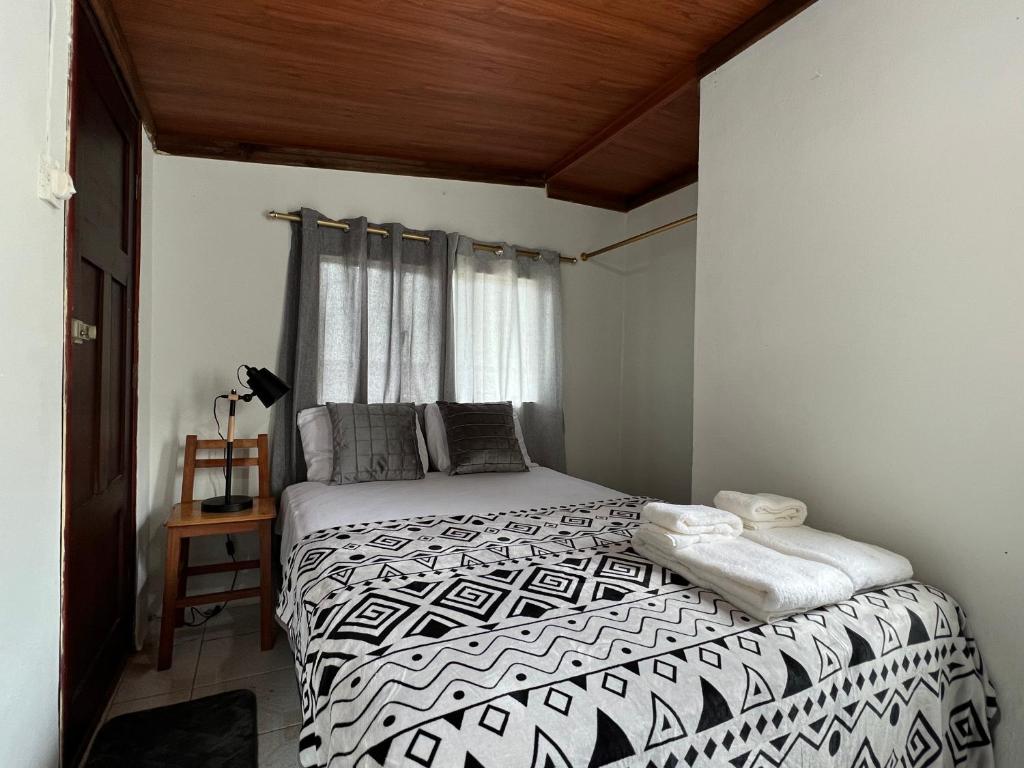 a bedroom with a black and white bed with a window at Tiny apartment in the city rooftop terrace in Baños