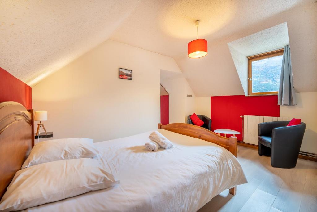 a bedroom with a white bed and a red wall at La bergerie in Azet