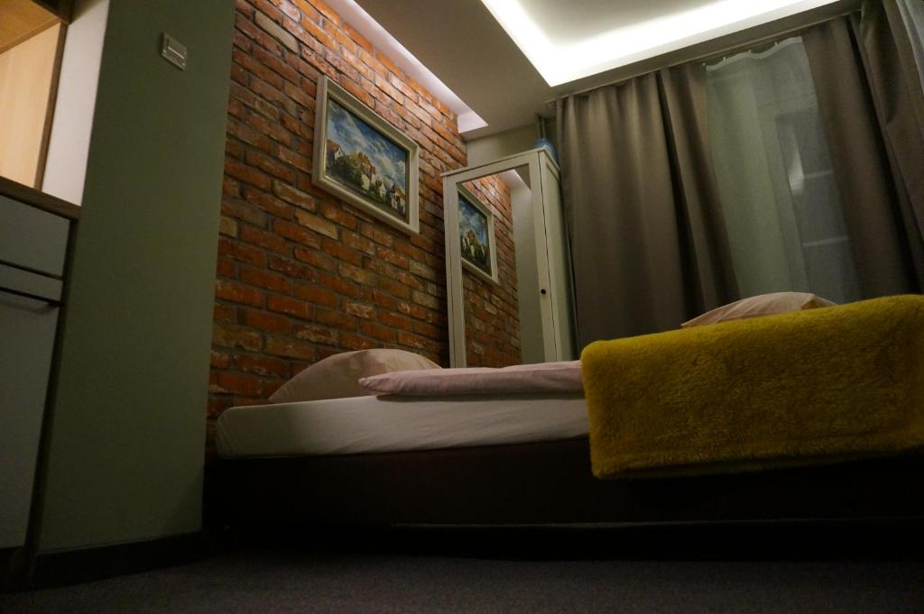 sypialnia z łóżkiem i ceglaną ścianą w obiekcie Pokój Miejski w Zielonej Górze