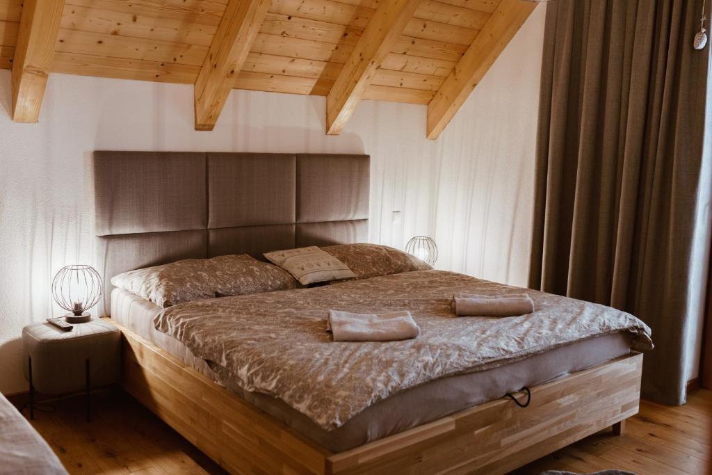 a bedroom with a large bed with a wooden headboard at Villa Štít Stará Lesná in Stará Lesná