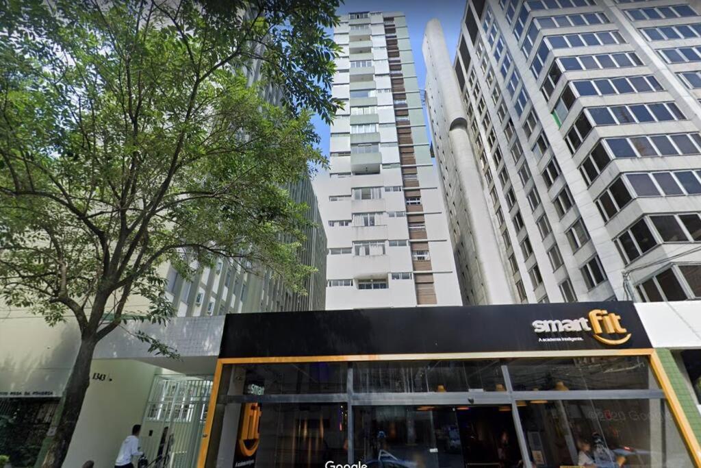 a bus parked in front of a tall building at Studio 1608 in São Paulo