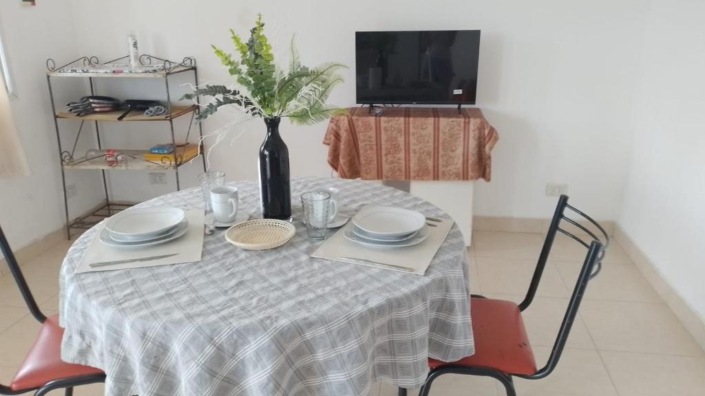 una mesa con platos y un jarrón encima en Paisajes en Monterrico