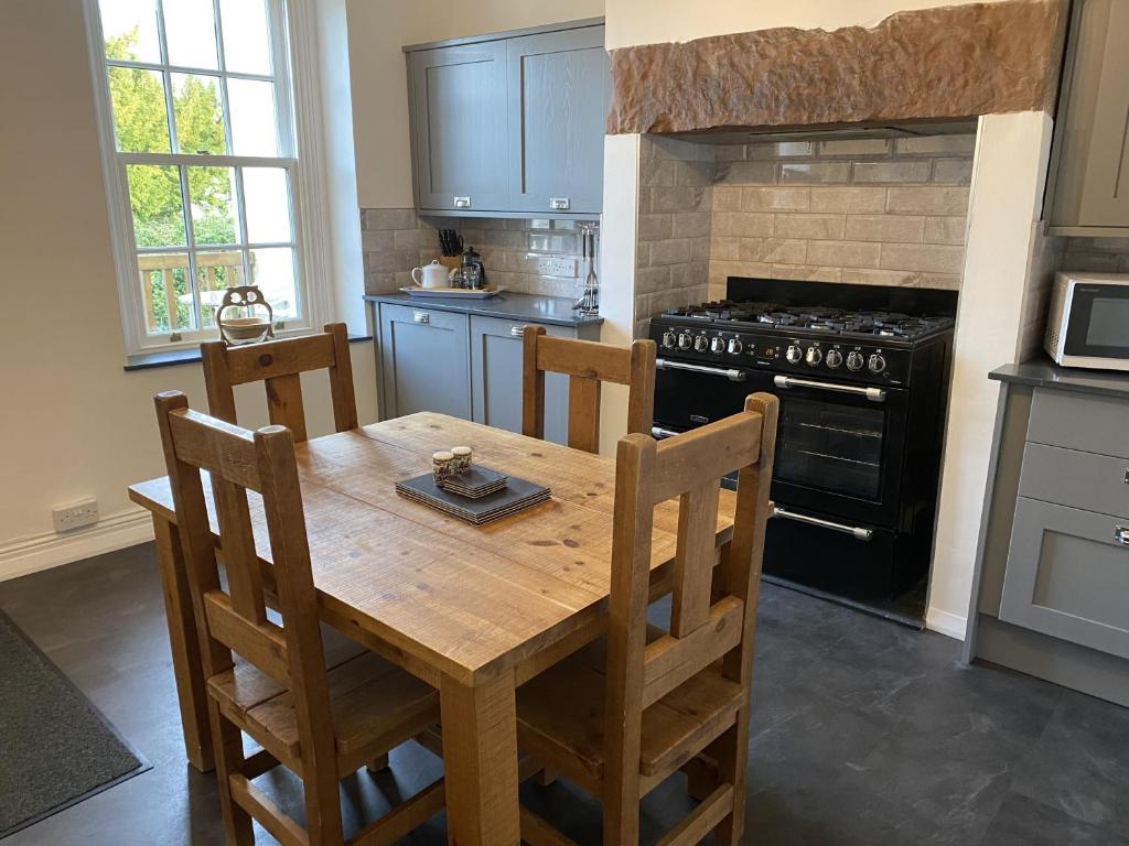 uma cozinha com uma mesa de madeira e um fogão em Tawny Cottage em Portinscale