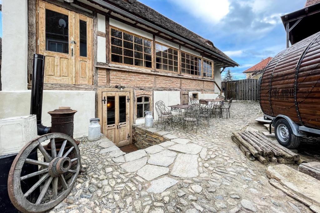 an old wooden building with a wooden wheel in front of it at Michelsberger Haus in Cisnadioara