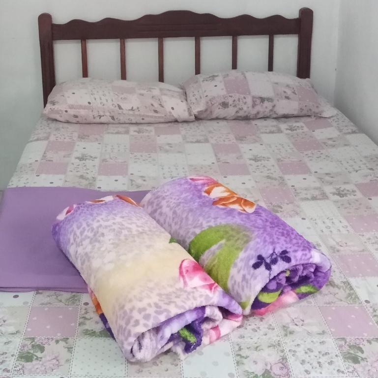 Una cama con cuatro almohadas encima. en Cantinho Jóia, en Aparecida