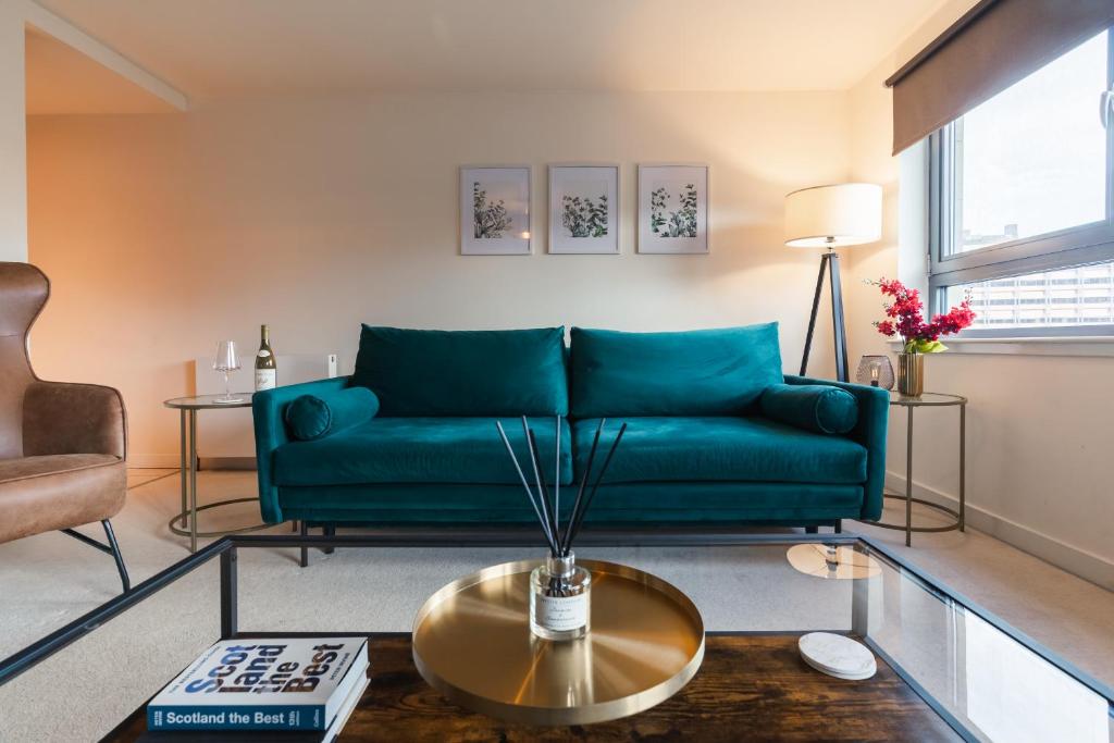 a living room with a green couch and a table at West End Escape - Prime Location in Glasgow