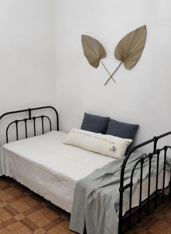 1 dormitorio con 1 cama con reloj de corazón en la pared en Casa Isa en San Juan