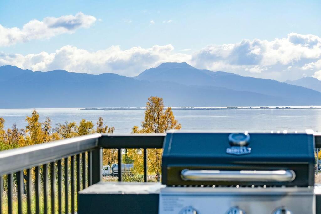 una cabina blu seduta su un balcone con vista sull'oceano di Rockfish Retreat at Kachemak Bay Kabins a Homer