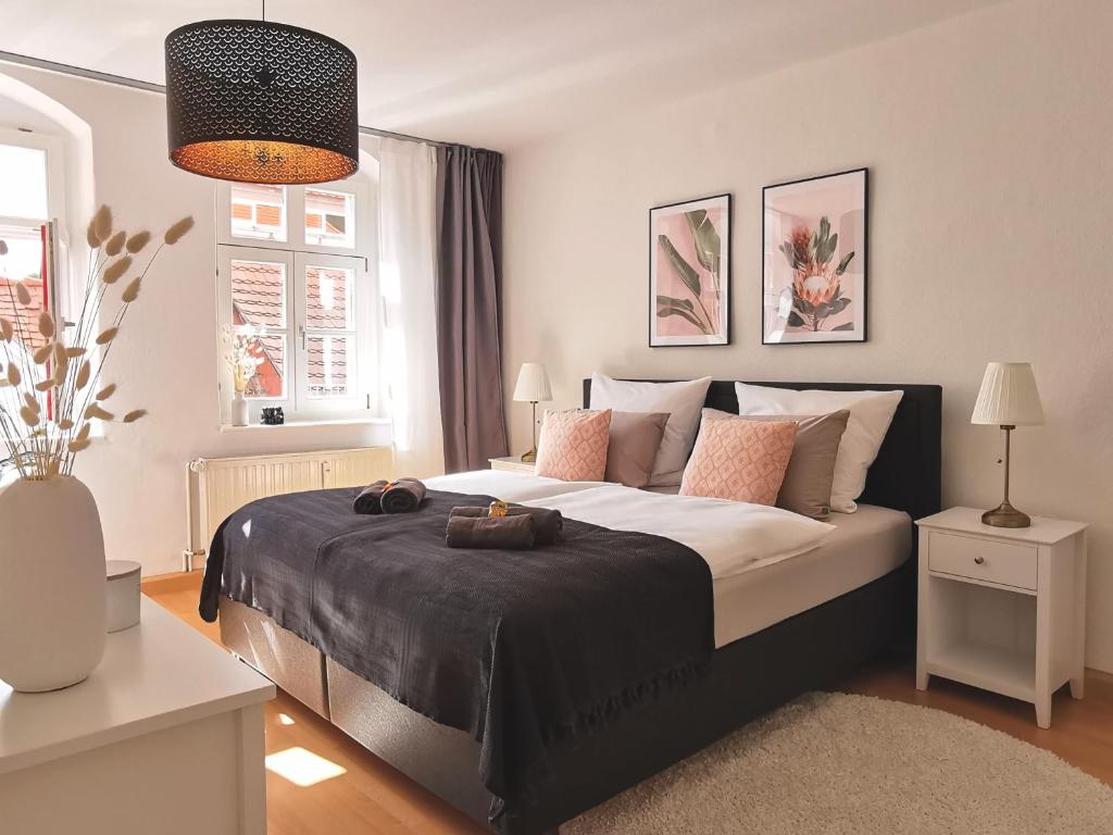 a bedroom with a large bed with brown shoes on it at Fynbos Apartments in der Altstadt, Frauenkirche, Netflix, Parkplatz in Meißen