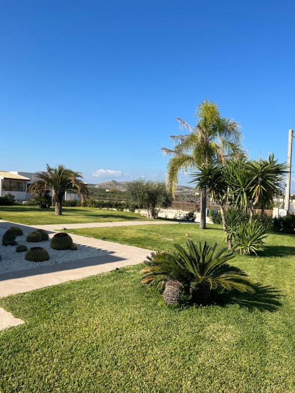een park met palmbomen en een stoep bij La Dimora apartments in Siculiana