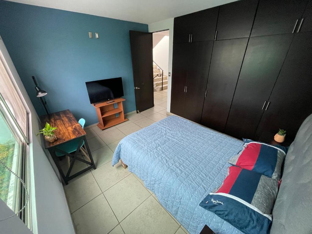 1 dormitorio con 1 cama y TV de pantalla plana en Equiped private rooms at nice residence in Morelia, en Morelia