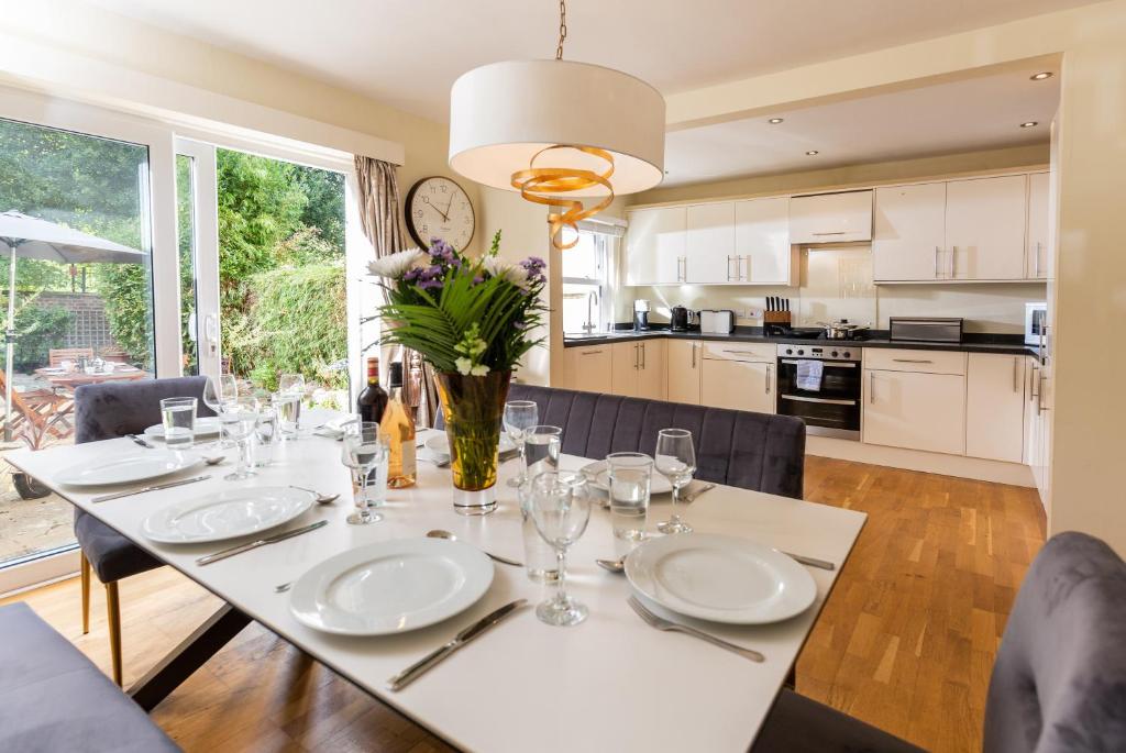 a kitchen and dining room with a table with glasses at Glensanda - By Luxury Apartments in Cheltenham