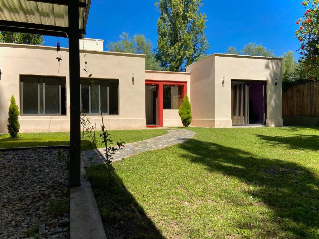 ein Haus mit einem Rasen davor in der Unterkunft ENCANTO DE CHACRAS- Moderna-A metros de la plaza in Chacras de Coria