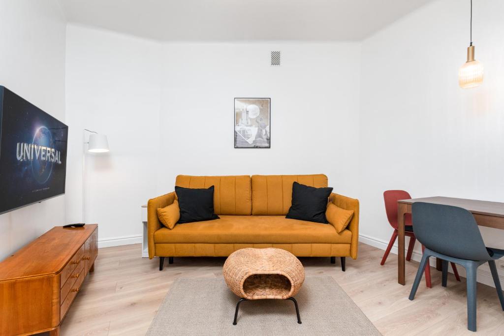 a living room with a yellow couch and a table at Apartament Plac Konstytucji by Your Freedom in Warsaw