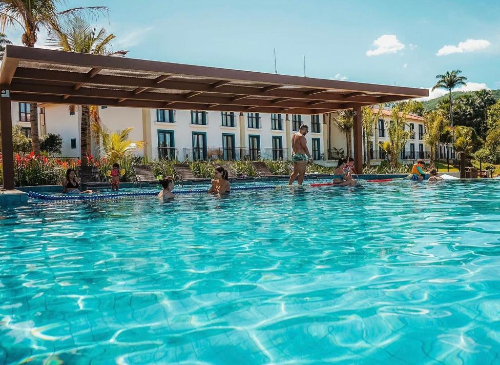 un grupo de personas en una piscina en Quarto em Quinta Santa Bárbara Ecoresort, en Pirenópolis