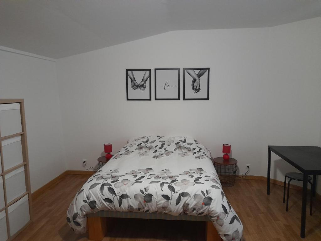 ein Bett in einem Schlafzimmer mit drei Bildern an der Wand in der Unterkunft Gîte Linglet in Fumay