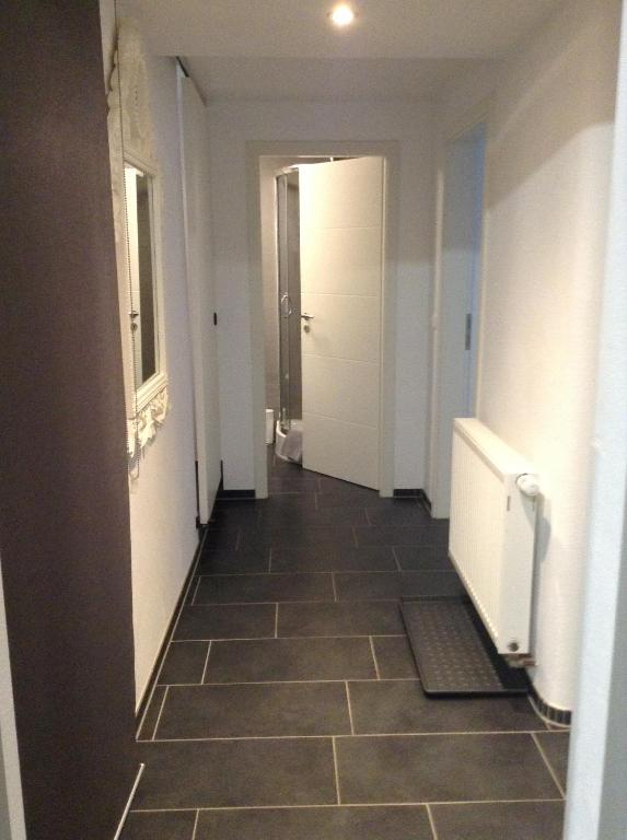 a hallway with a tile floor and a white door at EBH HOME in Filderstadt