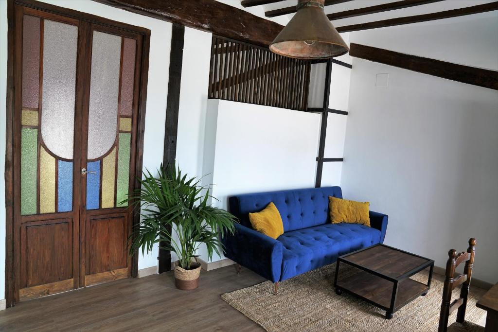 Sofá azul en una sala de estar con puerta en Coqueta Casita de Pescadores frente al Puerto, en Denia