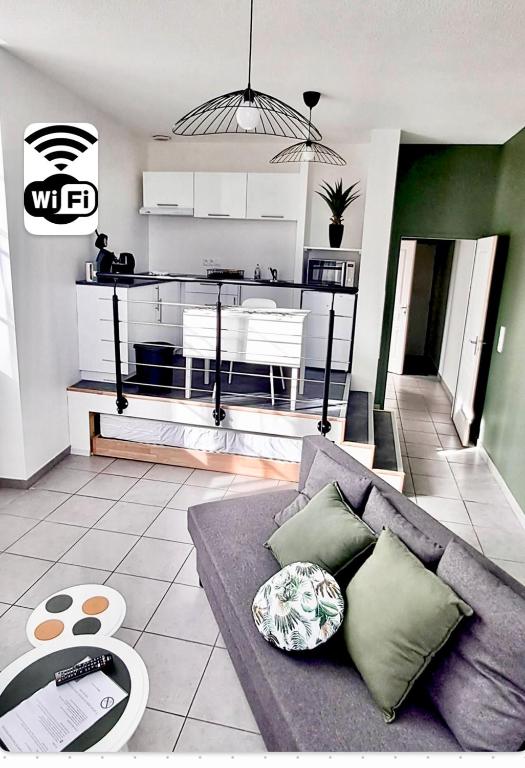 un salon avec un canapé et une cuisine dans l'établissement STUDIO Dole Grevy deux étoiles,, à Dole