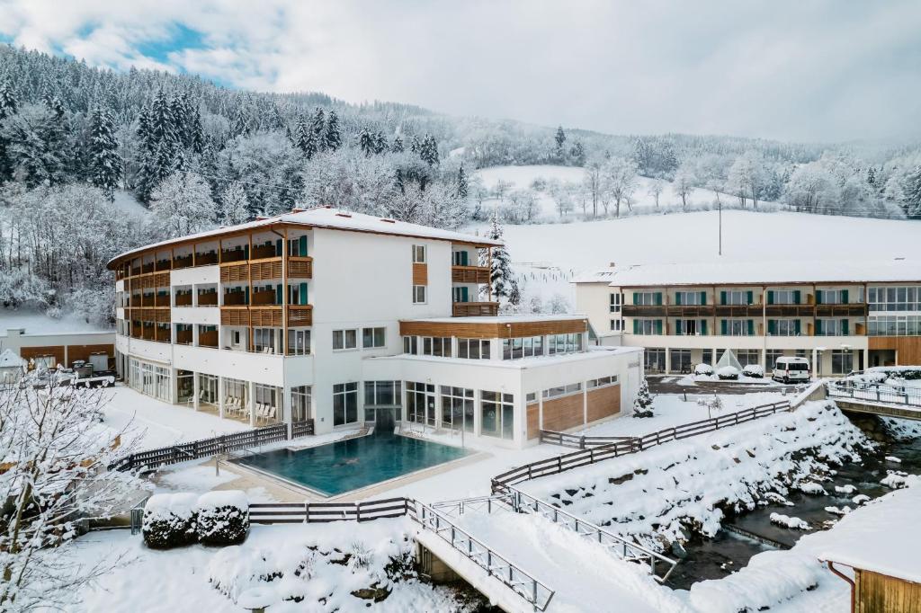 a building with a pool in the snow at Gesundheits- & Wellness Resort Weissenbach 