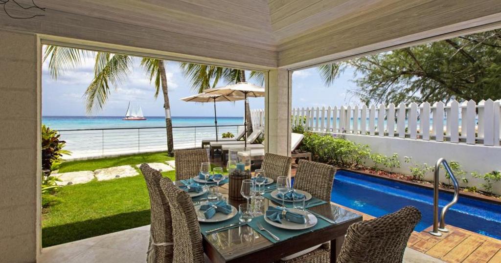 uma sala de jantar com uma mesa e vista para o oceano em Radwood 2 by Barbados Sothebys International Realty em Saint James