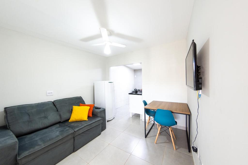 a living room with a couch and a table at Jahu Center Casas Un 1 in Jaú