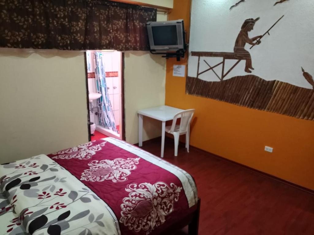 - une chambre avec un lit, une télévision et une table dans l'établissement Hotel Dido's, à Baeza
