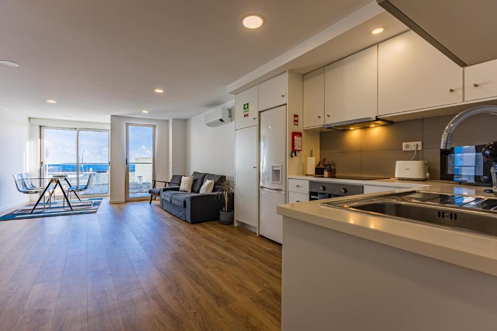 uma cozinha e sala de estar com vista para o oceano em Mare Nostrum Apartment em Ponta Delgada