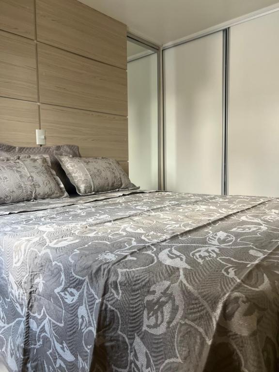 1 dormitorio con 1 cama grande y paredes de cristal en Apartamento no centro de Curitiba,bem localizado e confortável, en Curitiba