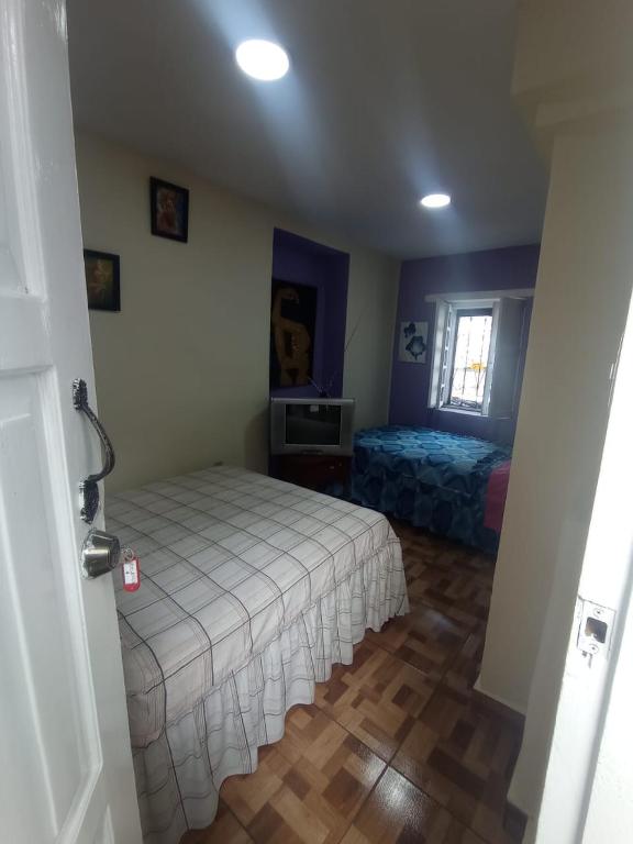 1 dormitorio con cama blanca y ventana en Hotel tanta Wasi, en Quito