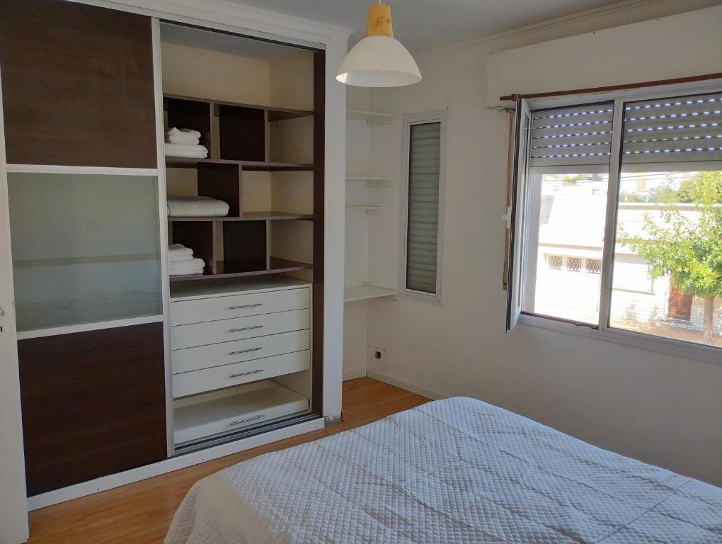 1 dormitorio con 1 cama, vestidor y ventana en URIBURU en Tandil