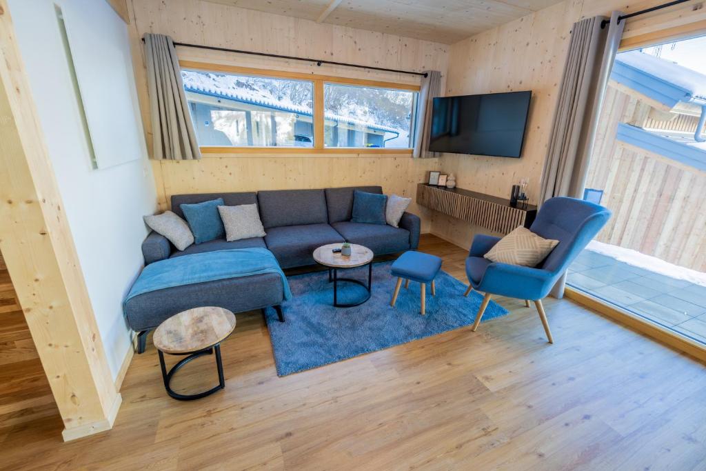 a living room with a blue couch and a tv at Chalet Bavaria in Sankt Lorenzen ob Murau