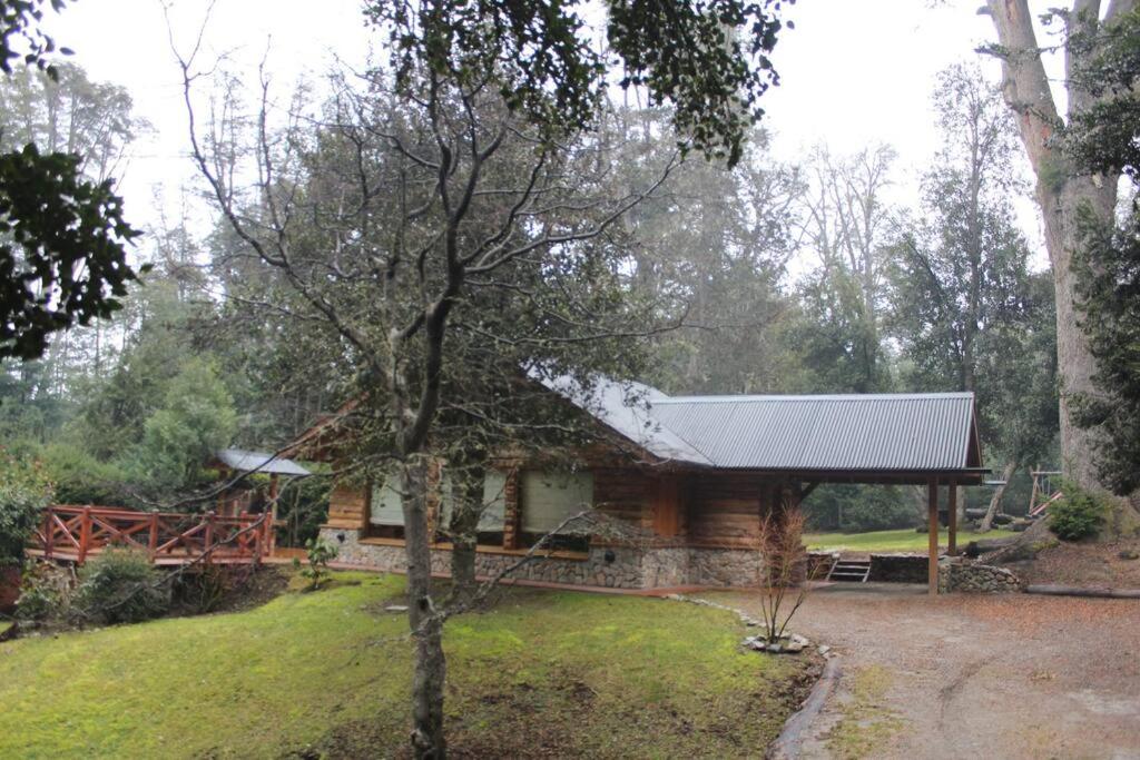 uma cabana de madeira no meio de um quintal em Casa en el bosque de Puerto Manzano em Villa La Angostura