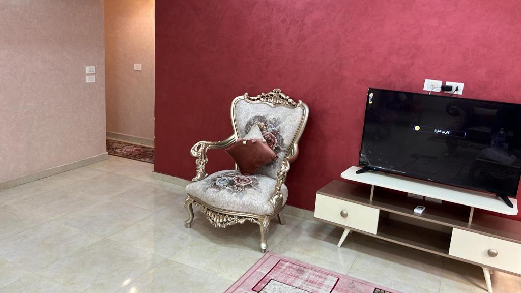 - un salon avec une chaise et une télévision dans l'établissement القاهره, au Caire