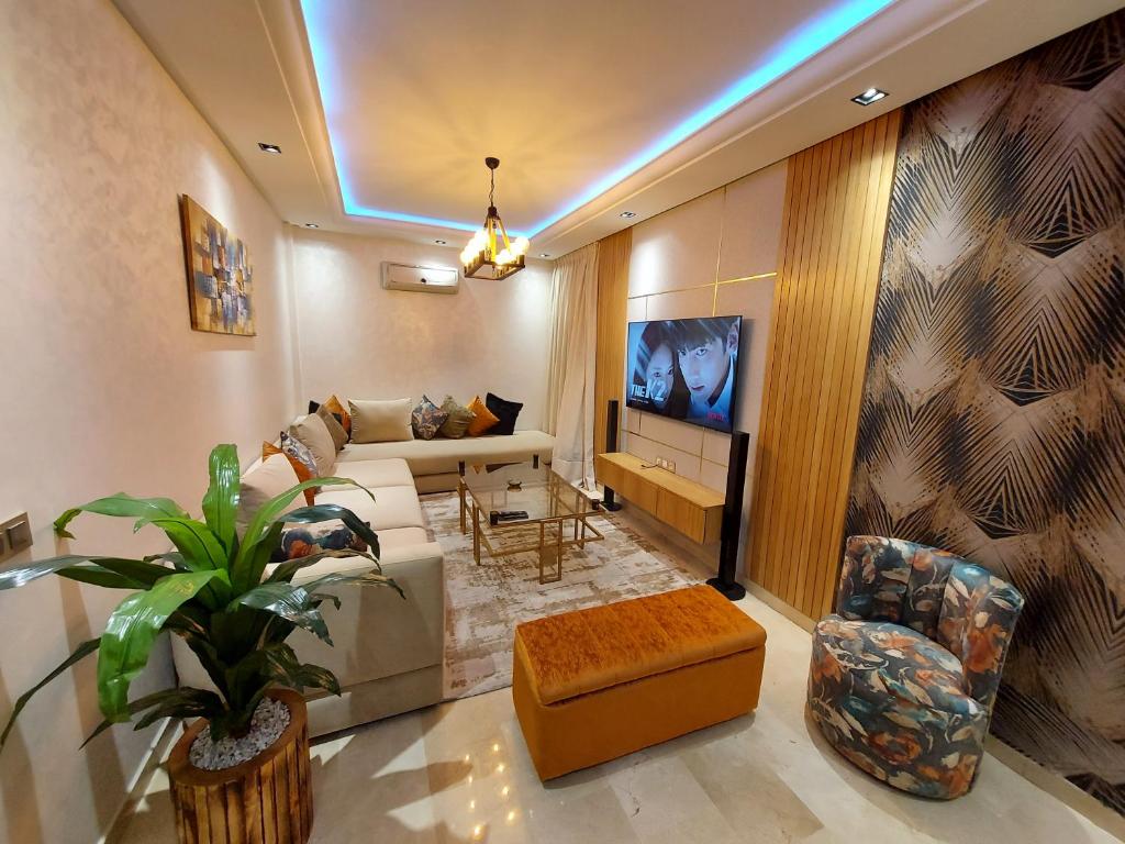a living room with a couch and a tv at luxury downtown apartment of 80m2 in front of Hassan 2 Mosquē and sea from family , pour famille , INTERDIT COUPLES ARAABIC NON MARIÉ, FORBIDDEN UNMARRIED ARAABIC COUPLES basement car park in Casablanca