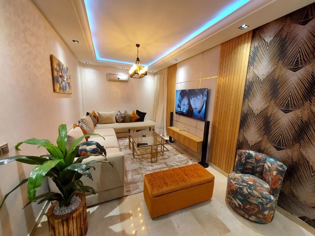 - un salon avec un canapé et une télévision dans l'établissement luxury downtown apartment of 80m2 in front of Hassan 2 Mosquē and sea from family , pour famille , INTERDIT COUPLES ARAABIC NON MARIÉ, FORBIDDEN UNMARRIED ARAABIC COUPLES basement car park, à Casablanca