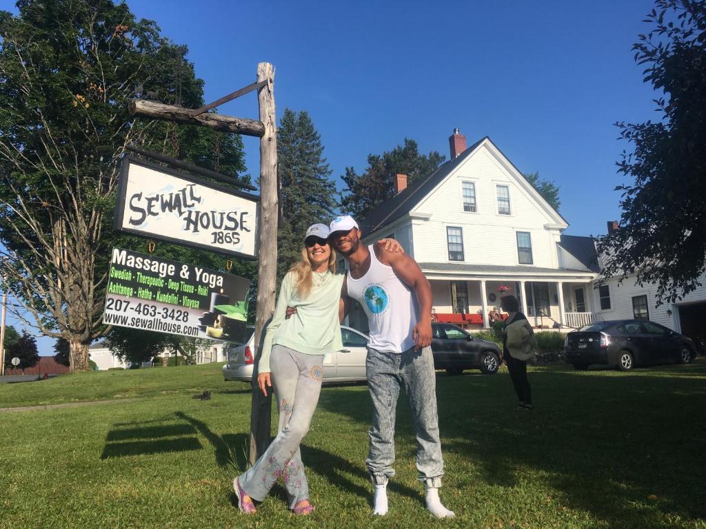 a man and a woman standing next to a sign at Sewall House Yoga Retreat in Island Falls