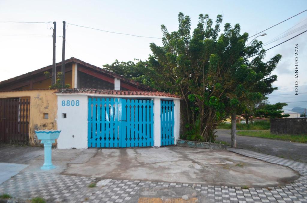 niebiesko-biała brama przed domem w obiekcie Casa de Praia em Mongaguá w mieście Mongaguá