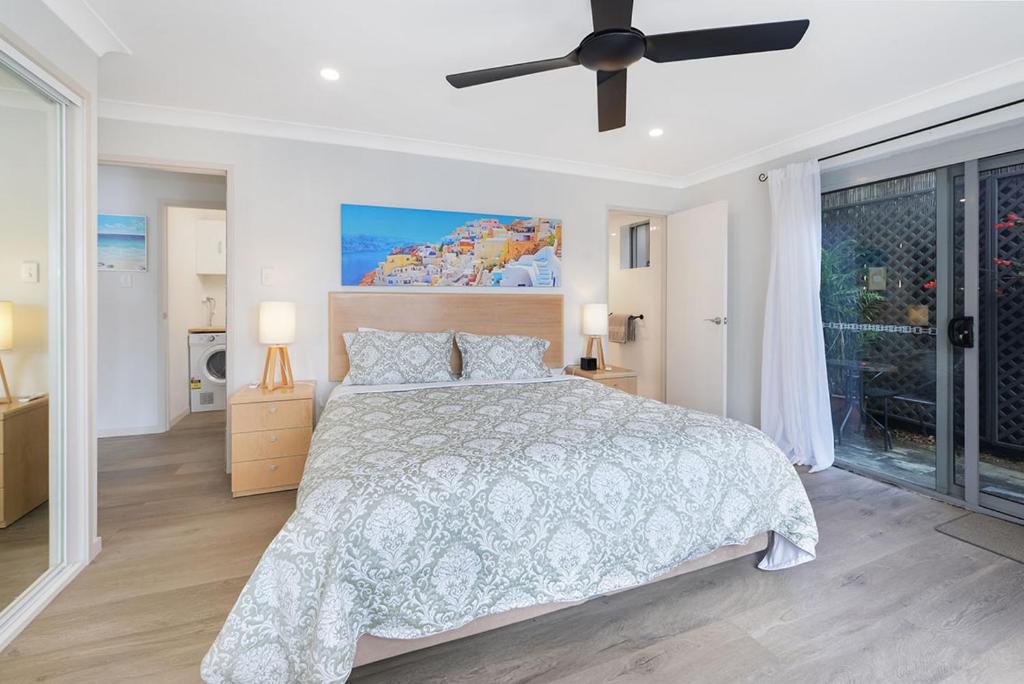 um quarto com uma cama e uma ventoinha de tecto em Tiarri Terrigal em Terrigal