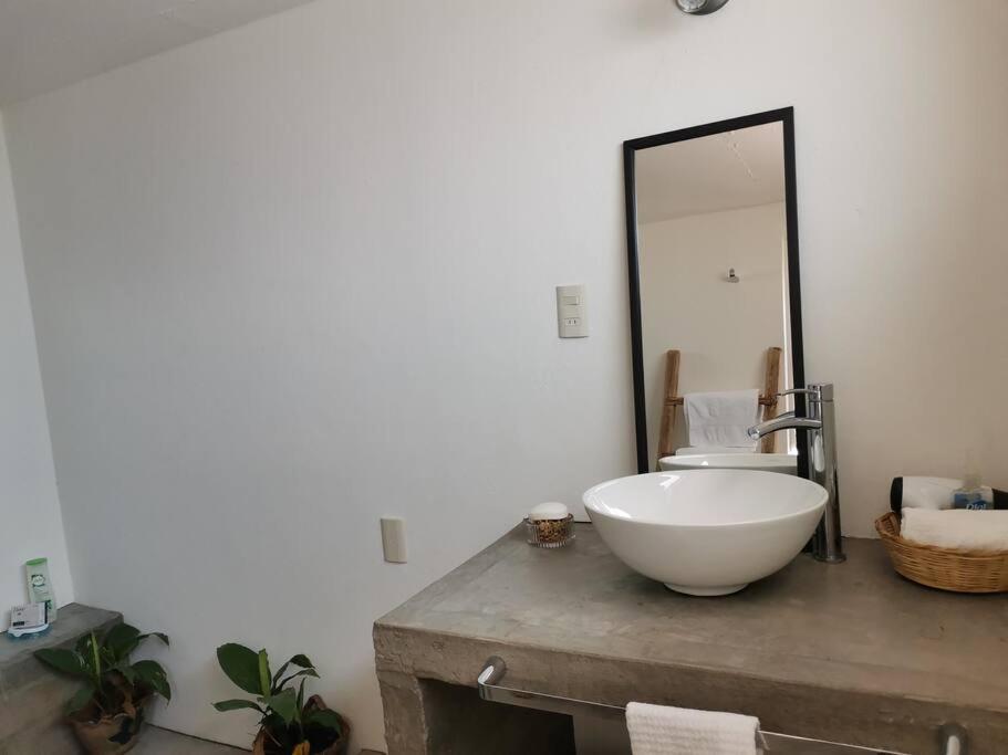uma casa de banho com um lavatório e um espelho. em Bugambilias 203 Oaxaca em Oaxaca de Juárez