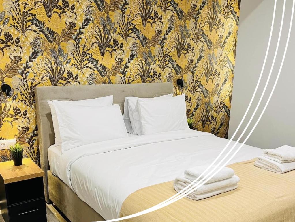 um quarto com uma cama e um papel de parede amarelo e preto em Raise Averof Serviced Apartments em Atenas