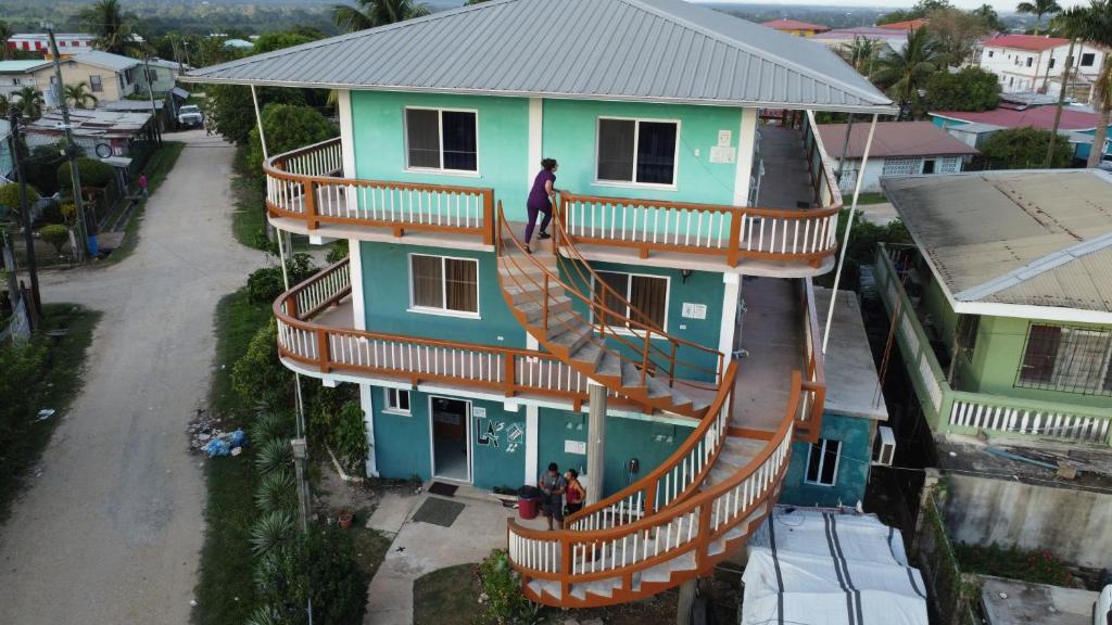 un hombre parado en el balcón de una casa con escaleras en Hilltop Horizon Guesthouse, en San Ignacio
