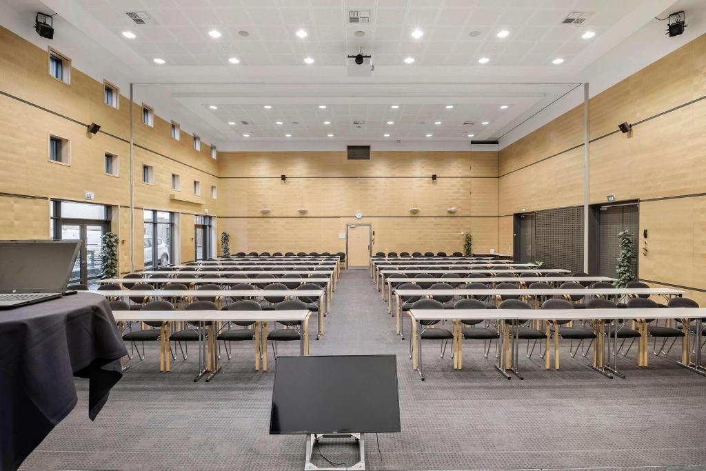 Habitación grande con hileras de mesas y sillas en Hotel Svendborg, en Svendborg