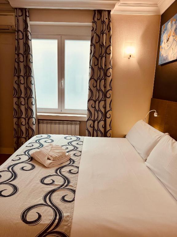 A bed or beds in a room at Hostal Abadia Madrid